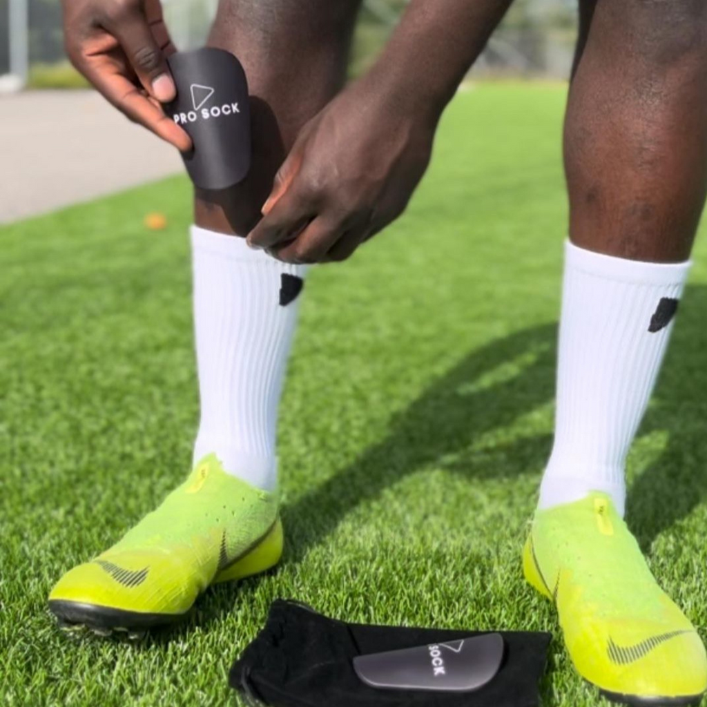 Fotbollsspelare som använder Mini benskydd under match